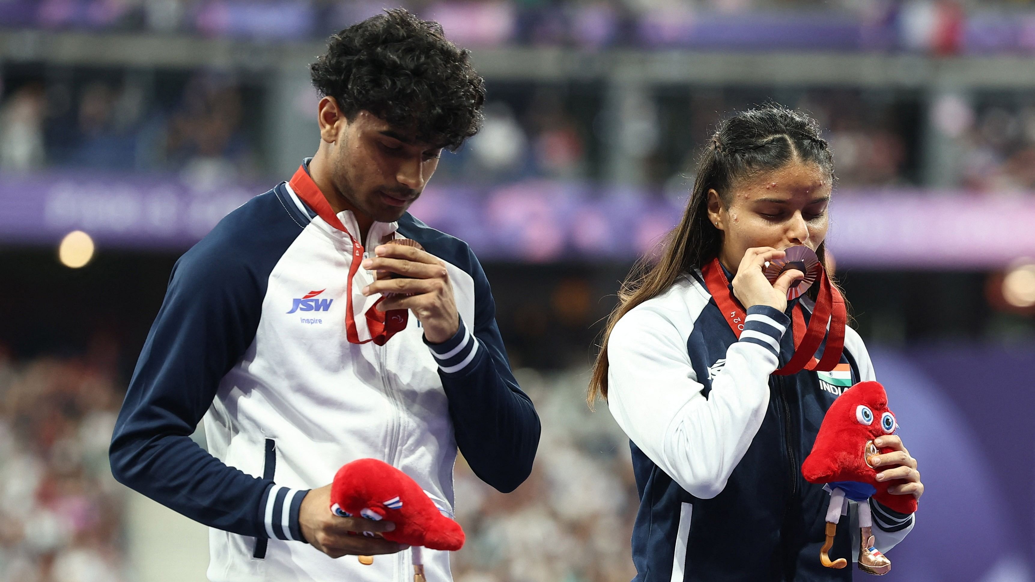 <div class="paragraphs"><p>Bronze medallists Simran of India and guide Abhay Singh celebrate on the podium</p></div>